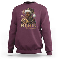 Maroon crewneck sweatshirt with front holiday graphic and gold "MAGIC" lettering
