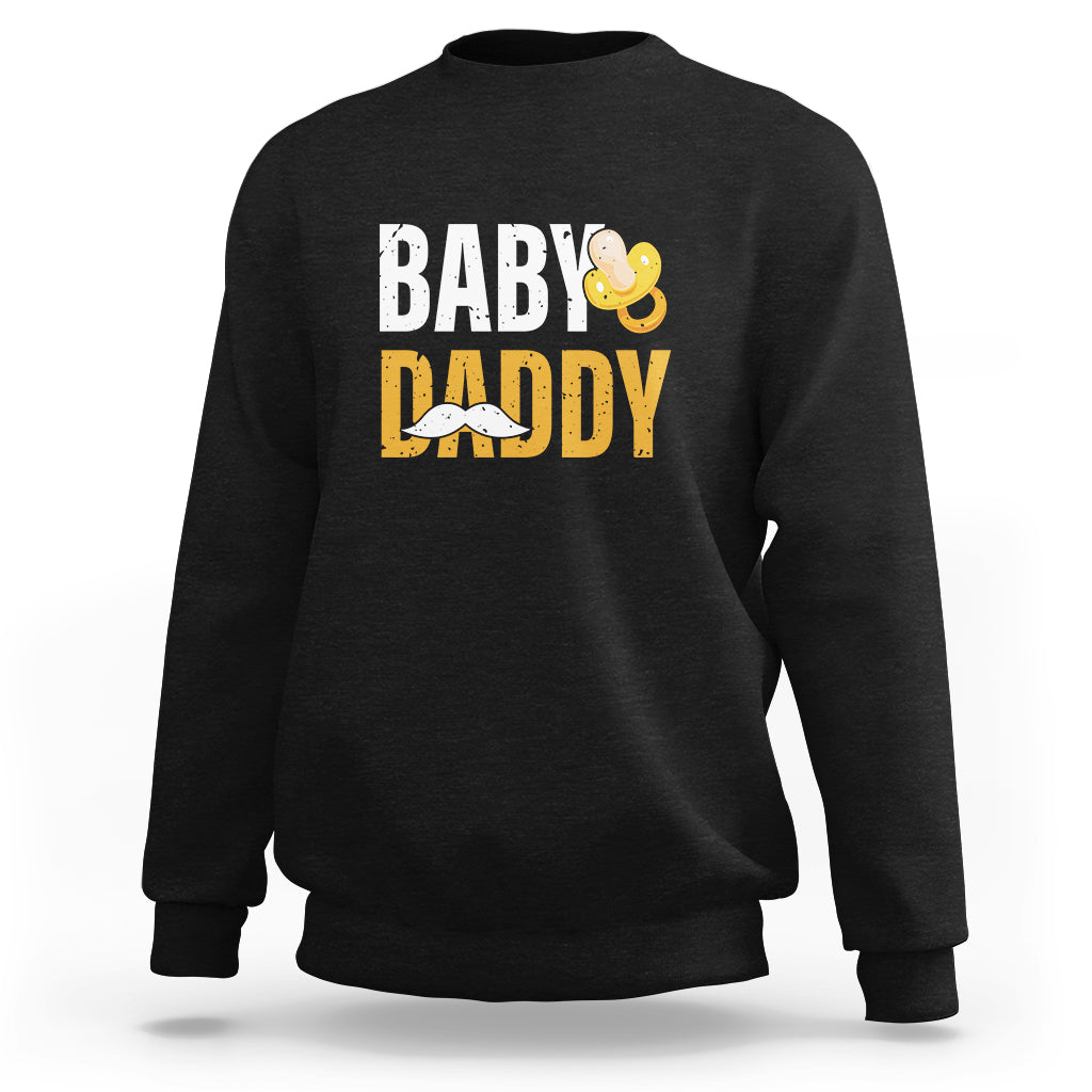 Black crewneck sweatshirt with 'BABY DADDY' text and baby icon graphic