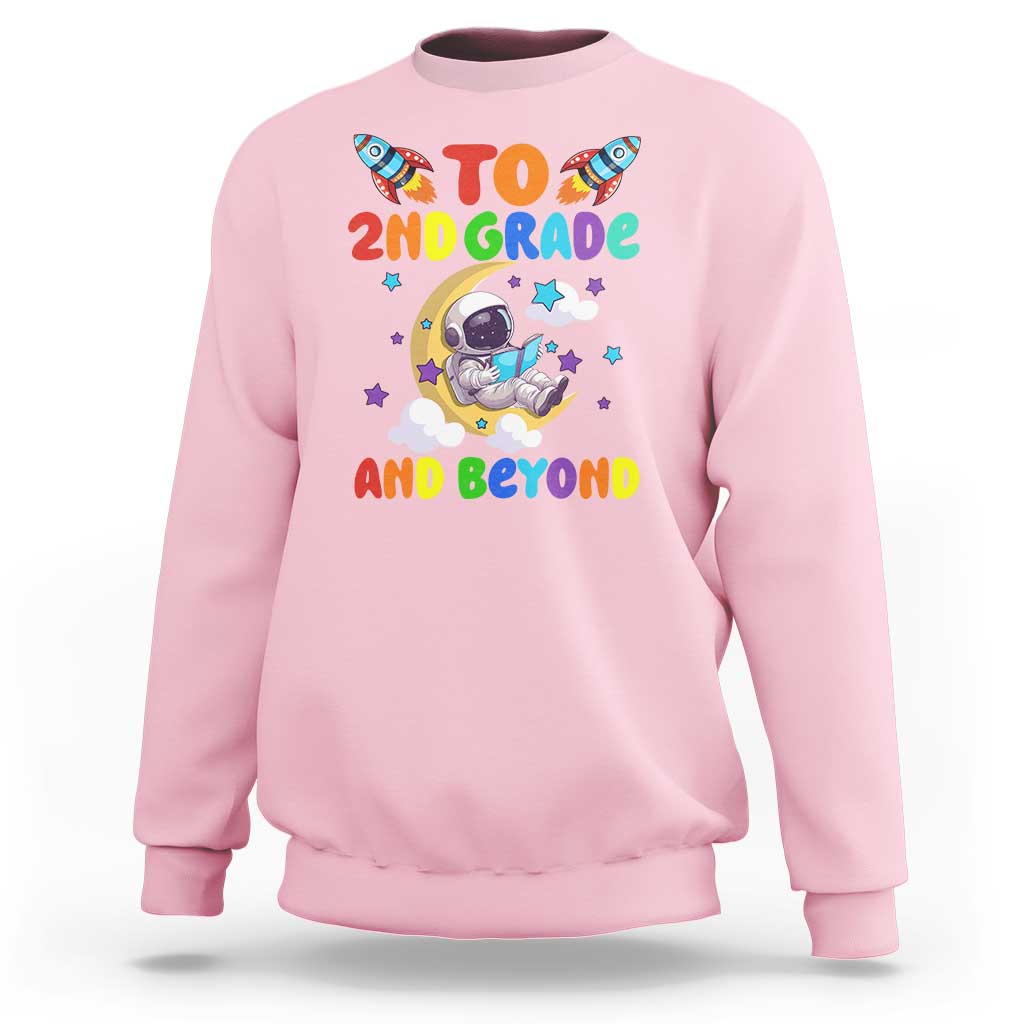 Light pink sweatshirt with astronaut graphic and text “To 2nd grade and beyond”