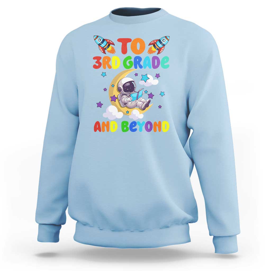 Light blue sweatshirt with astronaut graphic and “To 3rd Grade and Beyond” text