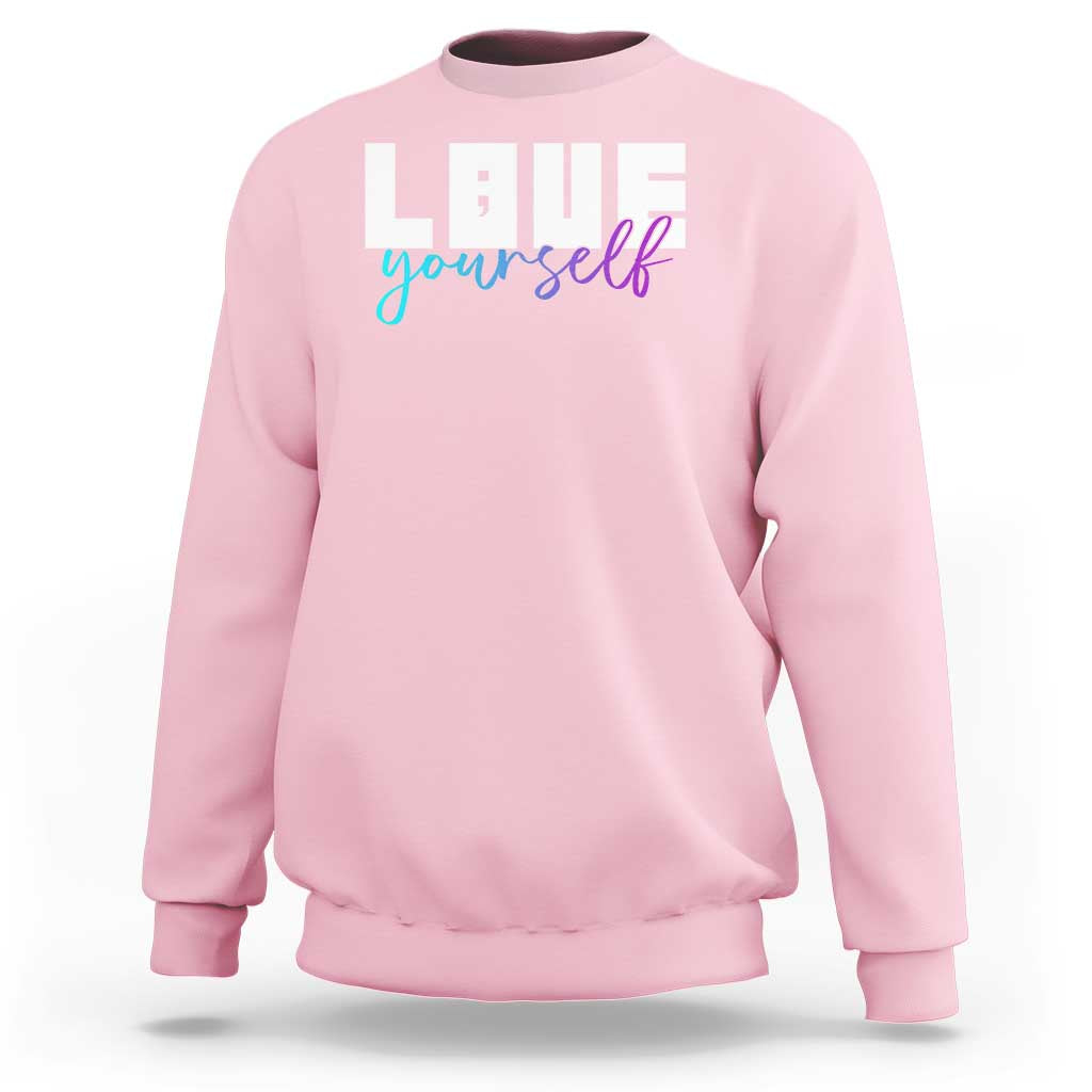 Light pink sweatshirt with “Love yourself” graphic and semicolon on front