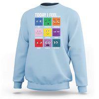 Light blue sweatshirt with colorful emotion face grid graphic and “Today I Feel...” text