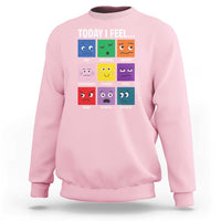 Light pink sweatshirt with colorful emotion face grid graphic and “Today I Feel...” text