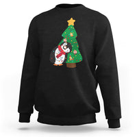 Black sweatshirt with penguin holding Christmas tree light graphic on chest