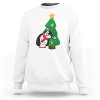 White sweatshirt with penguin holding Christmas tree light graphic on chest