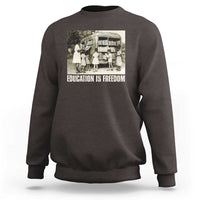 Dark chocolate sweatshirt with 'EDUCATION IS FREEDOM' front graphic, crewneck long sleeves
