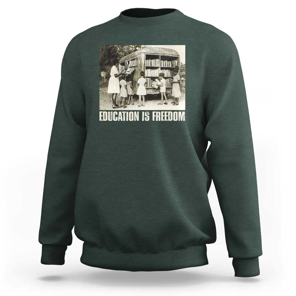 Dark forest green sweatshirt with 'EDUCATION IS FREEDOM' front graphic, crewneck long sleeves