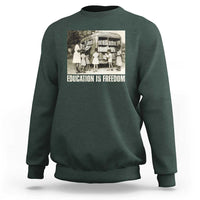 Dark forest green sweatshirt with 'EDUCATION IS FREEDOM' front graphic, crewneck long sleeves