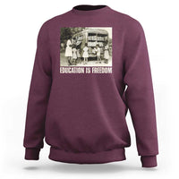 Maroon sweatshirt with 'EDUCATION IS FREEDOM' front graphic, crewneck long sleeves
