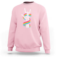 Light pink sweatshirt with skeleton rock hand graphic and pride rainbow flag colors on back