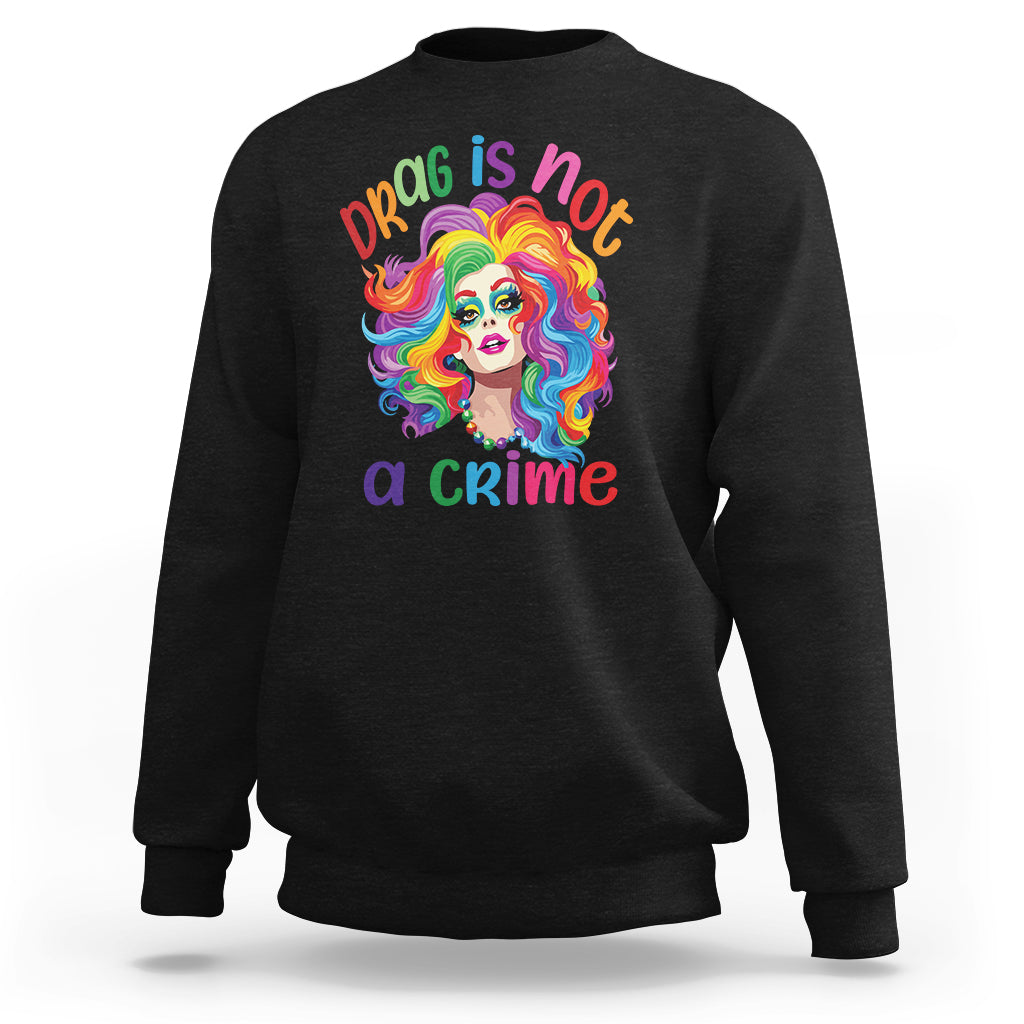 Black crewneck sweatshirt with colorful drag portrait and “Drag is not a crime” print