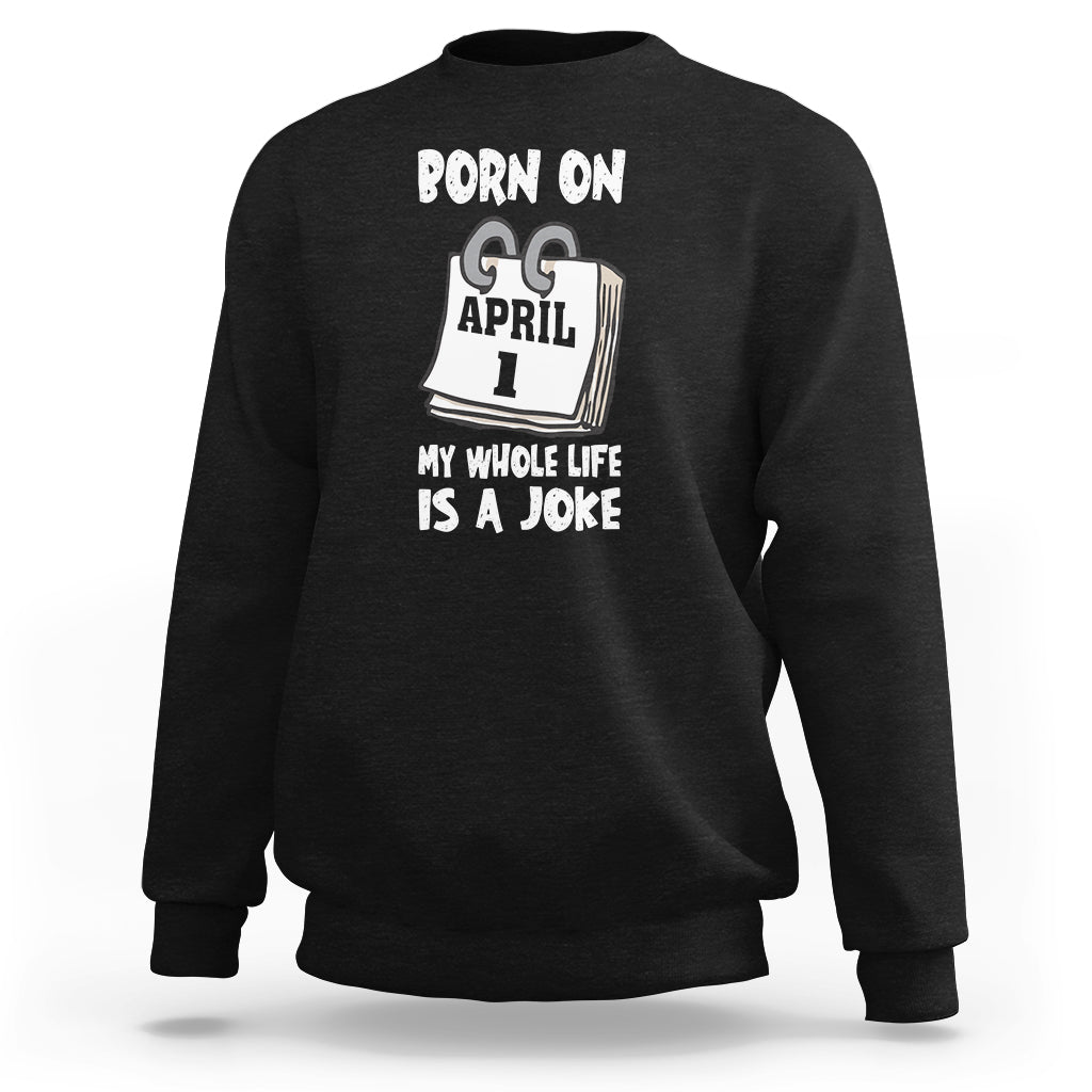 Black crewneck sweatshirt with "Born on April 1" joke text graphic on chest
