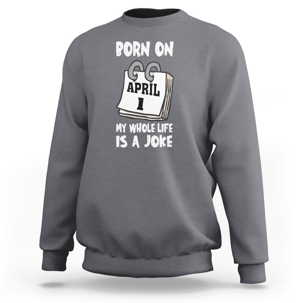 Charcoal gray crewneck sweatshirt with "Born on April 1" joke text graphic on chest