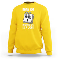 Daisy yellow crewneck sweatshirt with "Born on April 1" joke text graphic on chest