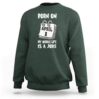 Dark forest green crewneck sweatshirt with "Born on April 1" joke text graphic on chest
