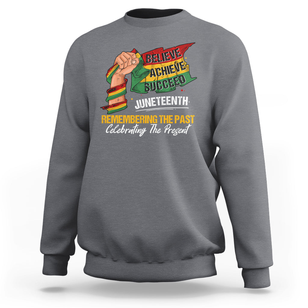 Gray sweatshirt with colorful Juneteenth graphic: raised fist, Believe Achieve Succeed