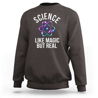 Dark brown sweatshirt with front graphic: “SCIENCE LIKE MAGIC BUT REAL” and atom icon