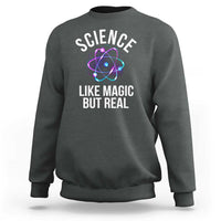 Charcoal gray sweatshirt with front graphic: “SCIENCE LIKE MAGIC BUT REAL” and atom icon