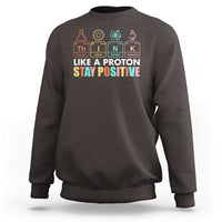 Dark gray science sweatshirt with 'Like a Proton Stay Positive' chest graphic