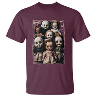 Maroon horror graphic T-shirt with a square print of creepy doll faces and bodies.