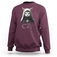 Maroon sweatshirt with front cat nun graphic and “The Cat” text