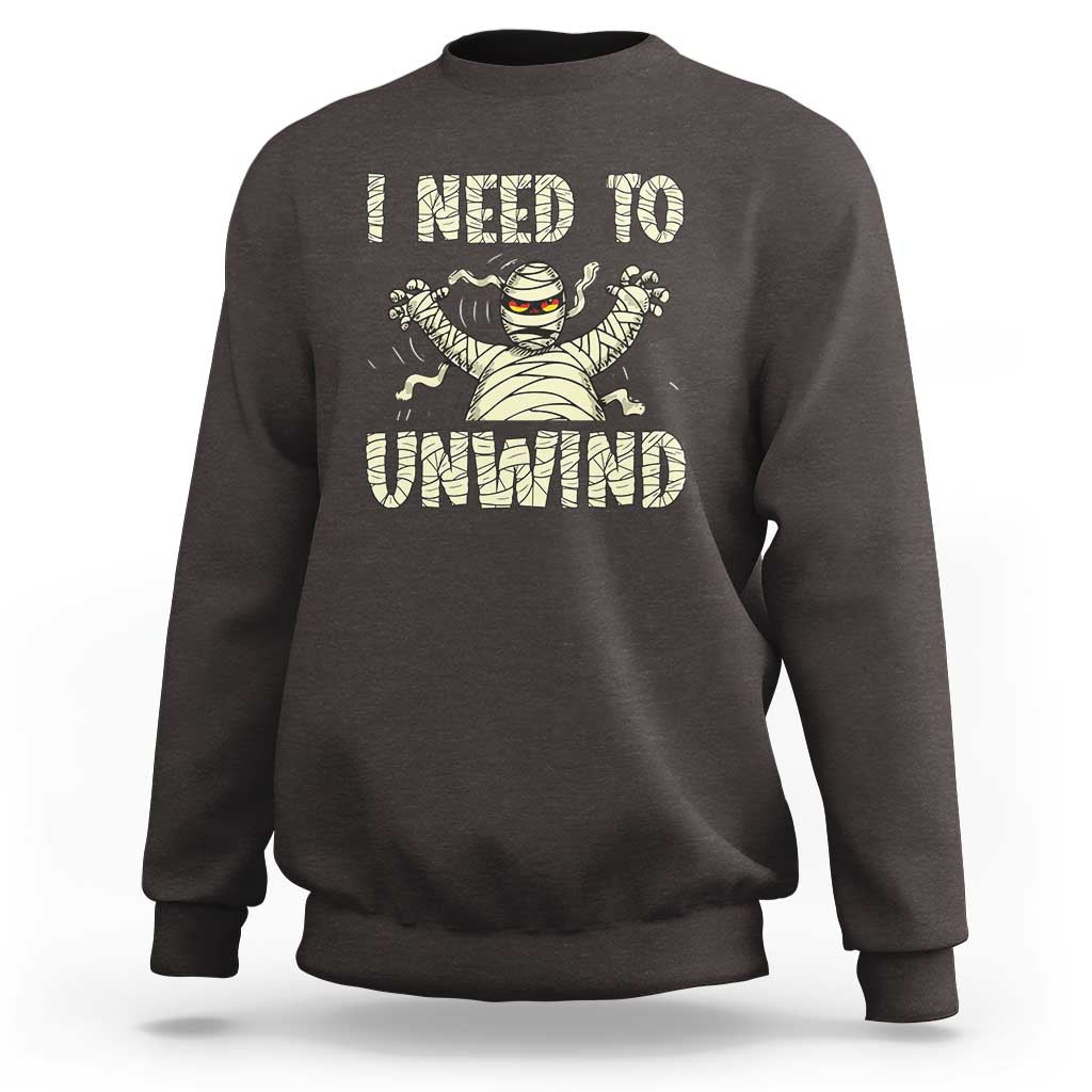 Dark brown Halloween mummy sweatshirt with 'I need to unwind' graphic on chest