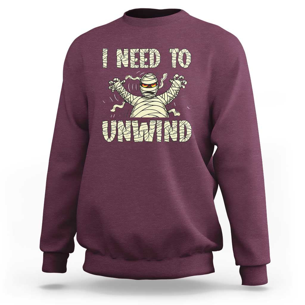 Maroon Halloween mummy sweatshirt with 'I need to unwind' graphic on chest