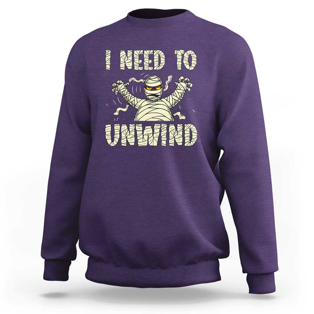 Purple Halloween mummy sweatshirt with 'I need to unwind' graphic on chest