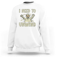 White Halloween mummy sweatshirt with 'I need to unwind' graphic on chest