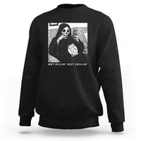 Black crewneck sweatshirt with grim reaper graphic and chilling slogan text