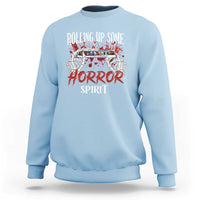 Light blue Halloween sweatshirt with front graphic reading “Rolling Up Some Horror Spirit”