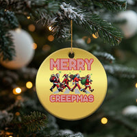 Gold round Christmas ornament with Merry Creepmas text and creepy characters illustration