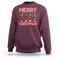 Maroon crewneck sweatshirt with “MERRY” and “CREEPMAS” graphic and horror characters