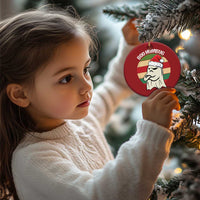 Red round “BOO HUMBUG” ghost ornament held near a Christmas tree