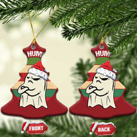 Red tree-shaped ornament with ghost in a Santa hat and partial “HUM” text