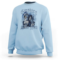 Light blue crewneck sweatshirt with blue skeleton smoking graphic on front