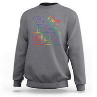 Charcoal gray crewneck sweatshirt with colorful “It’s Okay To Say Gay” graphic