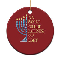 Red circular ornament with menorah graphic, “In a world full of darkness, be a light” text
