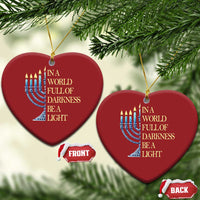 Two red heart-shaped ornaments with menorah graphic and “In a world full of darkness, be a light”