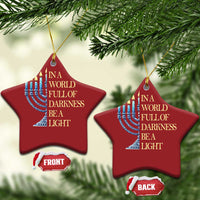Two red star-shaped ornaments with menorah illustration and “In a world full of darkness, be a light”