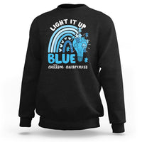 Black autism awareness sweatshirt with 'Light It Up Blue' rainbow puzzle graphic