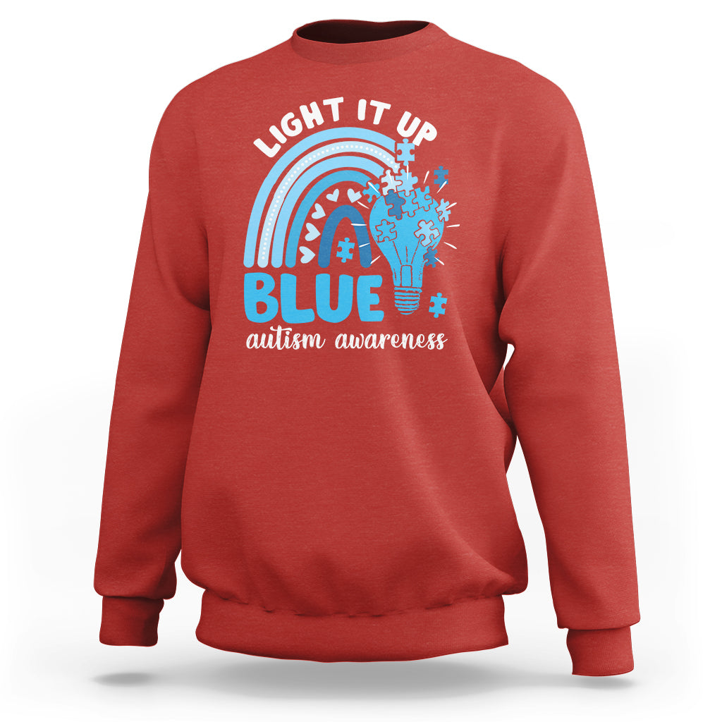 Red autism awareness sweatshirt with 'Light It Up Blue' rainbow puzzle graphic