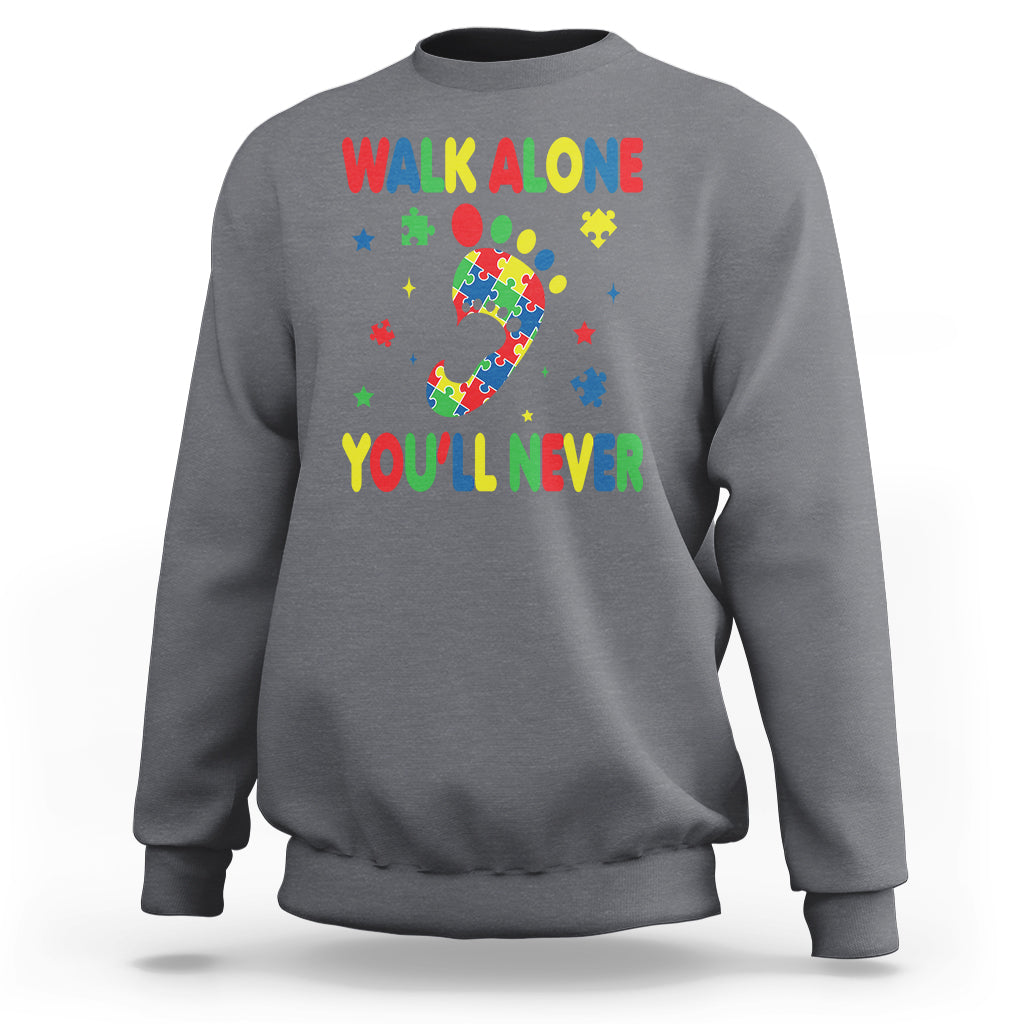 Charcoal gray crewneck sweatshirt with autism puzzle graphic and colorful "WALK ALONE" and "YOU'LL NEVER"