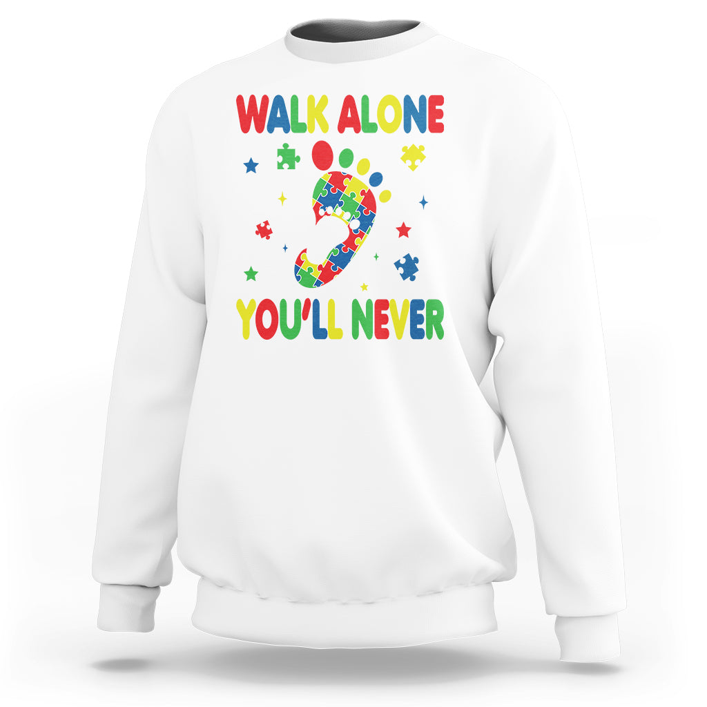 White crewneck sweatshirt with autism puzzle graphic and colorful "WALK ALONE" and "YOU'LL NEVER"