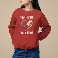 Red sweatshirt with heart graphic and "YOU'LL NEVER WALK ALONE" text.