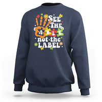 Navy autism awareness sweatshirt with colorful “See the able not the label” graphic.