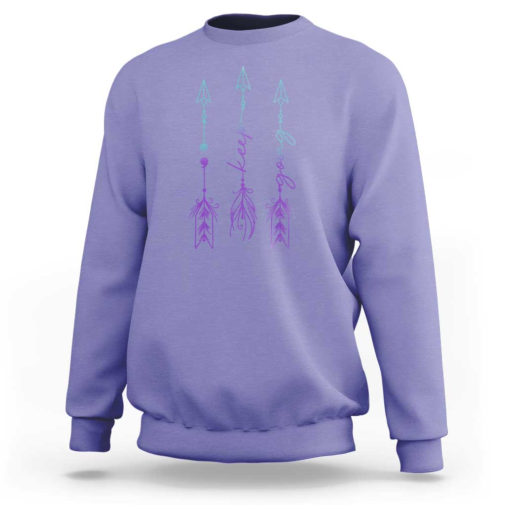 Lavender crewneck sweatshirt with purple and teal arrow-and-script graphic on back