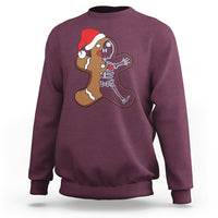Maroon sweatshirt with cartoon gingerbread character and skeleton nurse graphic on chest