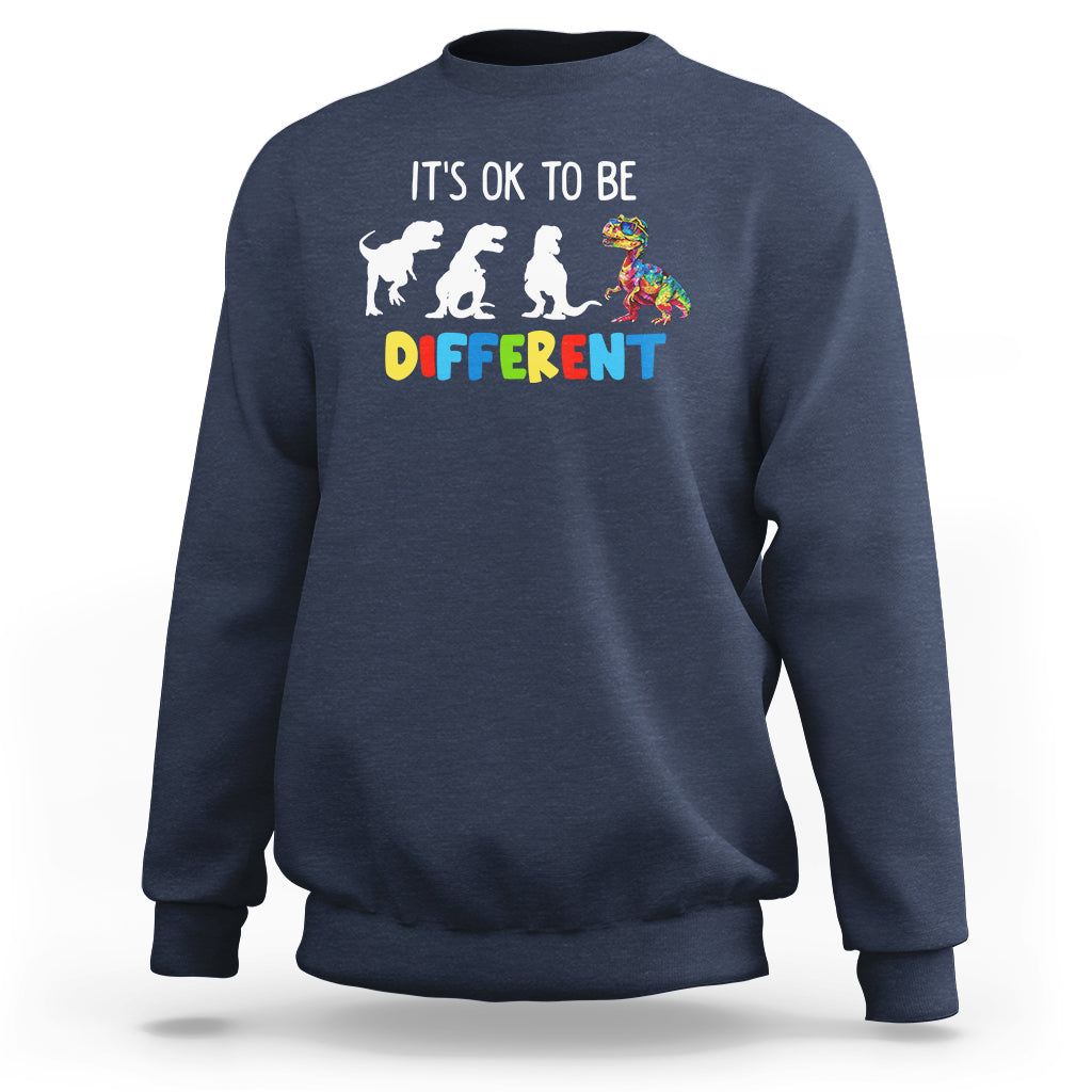 Navy crewneck sweatshirt with “It’s ok to be different” dinosaur puzzle graphic