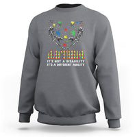 Charcoal gray autism awareness crewneck sweatshirt with skeleton puzzle graphic and rainbow text